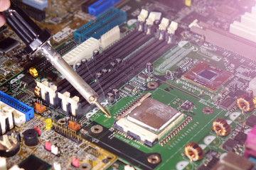 Soldering to a circuit Board of a computer close up.