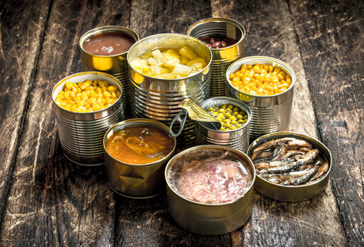 Various canned vegetables, meat, fish and fruits in tin cans.