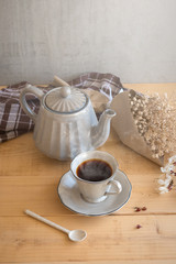 Tea set is Gray on a wooden background. Teapot, creamer, Cup and saucer on the table. Ceramic kitchenware