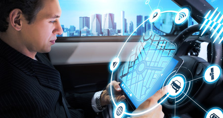 Young man watching tablet PC in autonomous car.