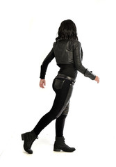 Fototapeta premium full length portrait of black haired girl wearing leather outfit. standing pose view from behind, on a white background