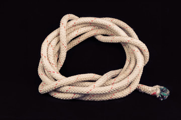 Roll of old rope on black background