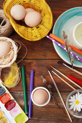 Painting Easter Eggs with Bruses, Pencils and Paints. Flat Lay. Top view. Dark Wooden Background. Vertical Image.