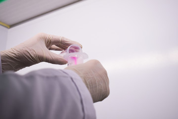 Hands transferring test samples to tubes