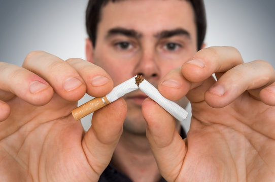 Man with broken cigarette - stop smoking concept