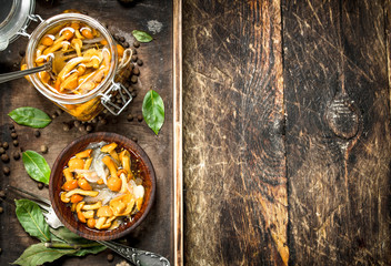 Pickled mushrooms in a bowl with spices and herbs.