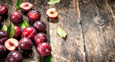Fresh, ripe plums with leaves.