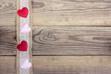 Rustic wooden background with sacking border and hearts. Copy space.