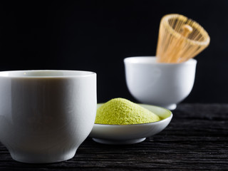 close up green tea, matcha power and whisk a cup of hot green tea on wooden table.traditional japanese drink