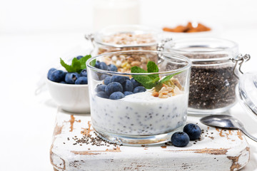 healthy breakfast with chia-pudding and fresh blueberries on white cutting board