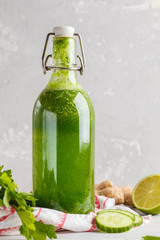 Healthy green vegetable detox smoothie in a glass bottle. Vegan cucumber, parsley green juice. Copy space