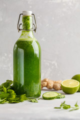 Healthy green vegetable detox juice in a glass bottle. Vegan cucumber, parsley green juice. Copy space