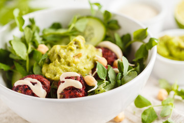 Green vegetable vegan salad with beets meatballs, Guacamole and tahini dressing. Healthy vegetarian food concept. Copy space