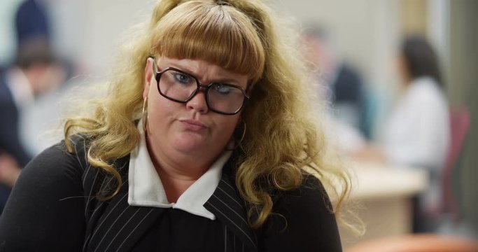 4K Portrait funny businesswoman looking intently at camera & nodding. Slow motion.