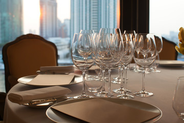 Wine glass set up on dinner table in the restaurant with sun light in the evening.