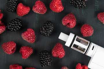 electronic cigarette and raspberries with blackberries on a dark background