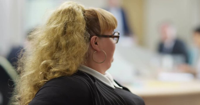 4K Funny extrovert businesswoman spinning on her chair & pulling faces. Slow motion.