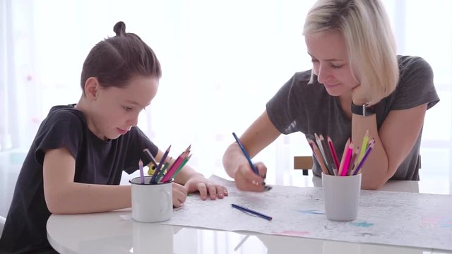 Mother and son drawing with pencil together