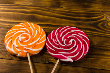 Sweet lollipops on rustic wooden background. Top view