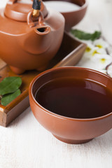 Ceramic teapot on a wooden tray.
