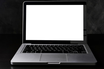 Silver laptop computer with white screen on dark background.