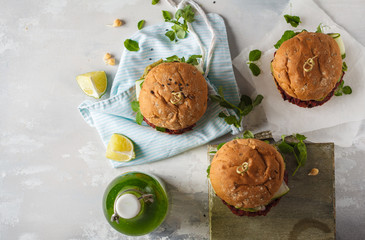 Vegan beet chickpea burgers with vegetables, Guacamole and rye bun with green juice. Healthy vegan food concept. Top view, copy space