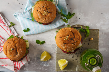 Vegan beet chickpea burgers with vegetables, Guacamole and rye bun with green juice. Healthy vegan food concept. Top view, copy space