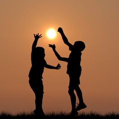 Children silhouettes playing with the sun