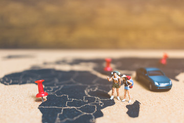 Miniature people travelers walking on world map ,