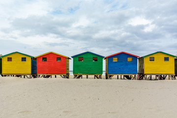 Obraz na płótnie Canvas The colourful beach huts on Muizenberg beach - a popular tourist attraction near Cape Town, South Africa