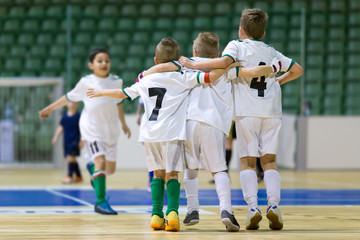 Indoor football soccer match for children. Happy kids together after winning futsal game. Chldren...