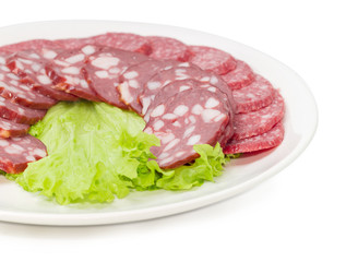 Sliced salami and smoked sausage on dish closeup