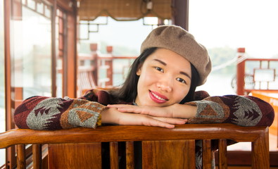 Portrait of fashionable asian girl in a wooden tourist boat.