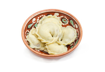 Cooked varenyky with fruit filling in a clay bowl