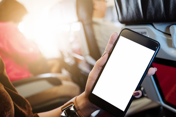 business woman sits in airplane watching his cell phone.