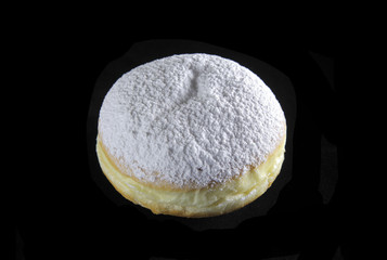 round doughnut with sugar on black background
