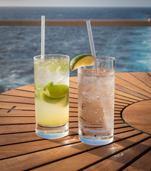 Non alcoholic drinks. Mint lemonade and sparkling water on wooden table on cruise vacation.