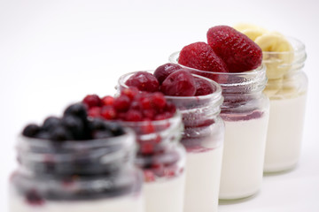 Fresh berries in the jar with the yogurt. On white background.