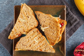 Peanut butter sandwiches with banana on dark plate. Healthy vegan breakfast concept. Top view