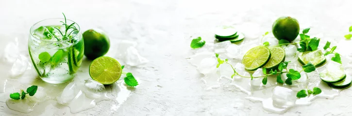 Meubelstickers Bestsellers in de keuken Zelfgemaakte limoenlimonade met komkommer, rozemarijn en ijs, witte achtergrond. Koude drank, ontgiftingswater. Kopieerruimte. Banner