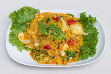 Fried crab with curry powder in white dish on the table.