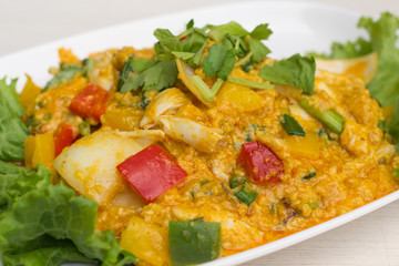 Fried crab with curry powder in white dish on the table.