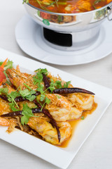 Fried shrimp with tamarind sauce in white dish on table.