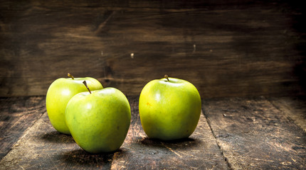 Green fresh apples. On wooden background.