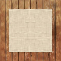 The wooden surface of the table with a linen tablecloth on top
