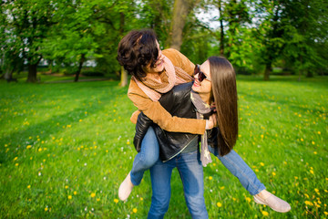 Two cute young women cheerfully spend time in the spring park