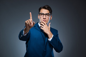 Businessman pressing virtual buttons on gray background