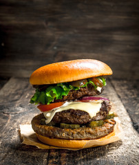 Big burger with beef, tomatoes and greens.