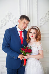 groom and bride in a bright interior. Wedding in red shades