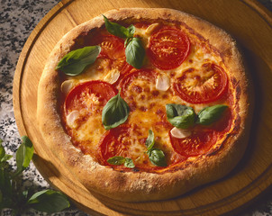 Pizza mit Tomaten,Käse und ganzen Basilikumblättern